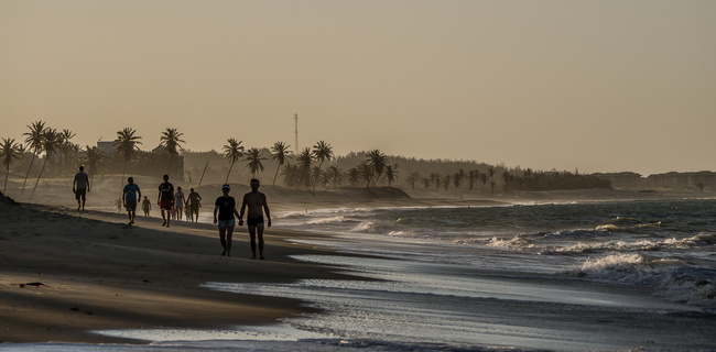Man and Woman walking on Cumbuco beach, Brazil